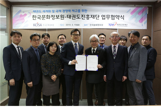 한국문화정보원과 태권도진흥재단 임직원이 업무협약서를 들고 단체사진을 찍고있다.